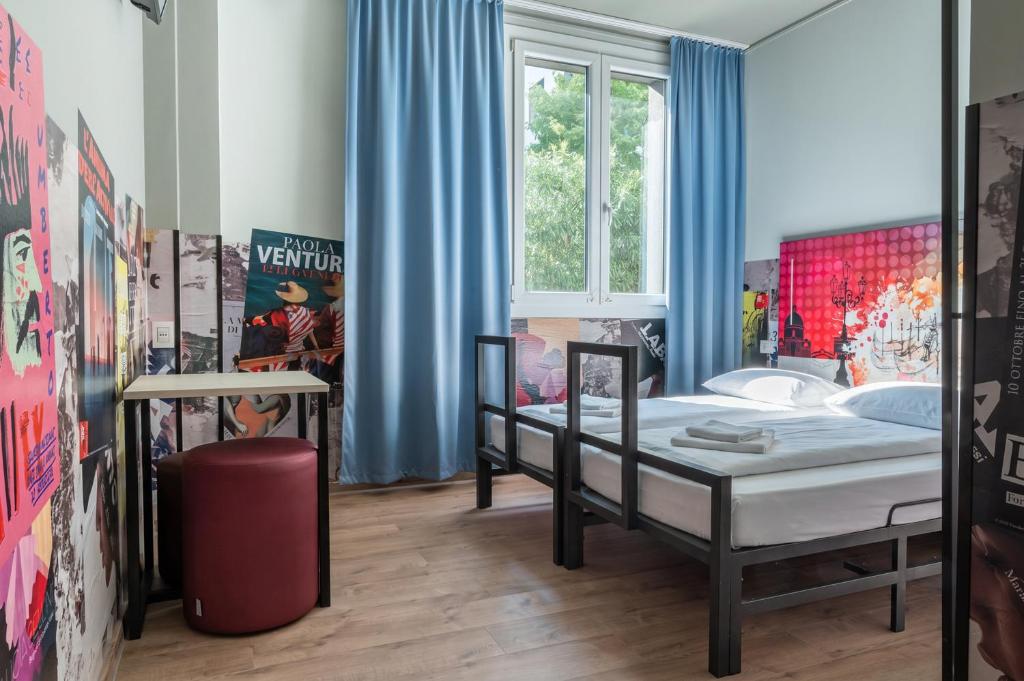 a bedroom with two beds and a window at a&o Hostel Venezia Mestre in Mestre