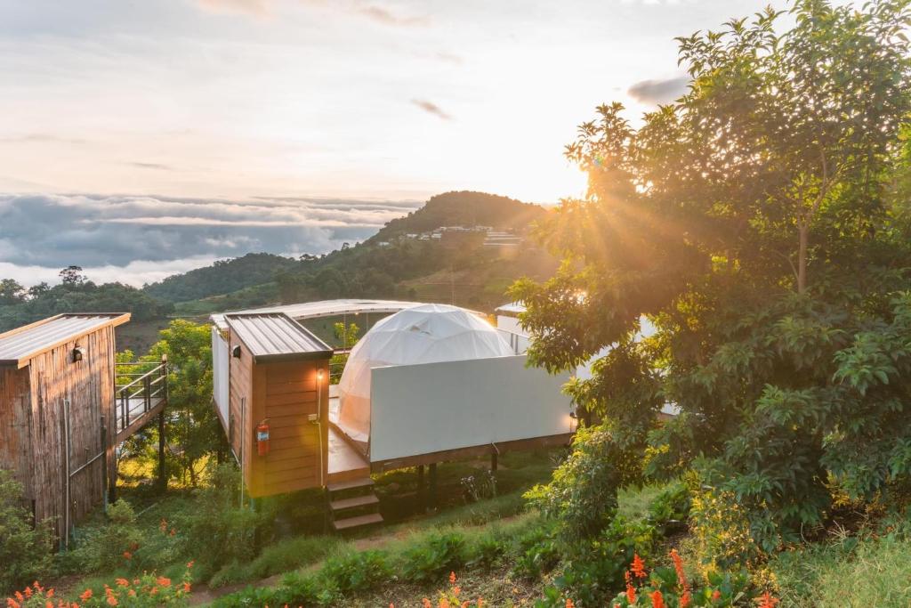 a house on a hill with a tent in a field at MonPhuView MonJam ม่อนภูวิว ม่อนแจ่ม in Mon Jam