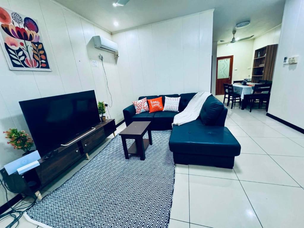 a living room with a couch and a flat screen tv at Apartment in Port Moresby - Short Stays in Port Moresby