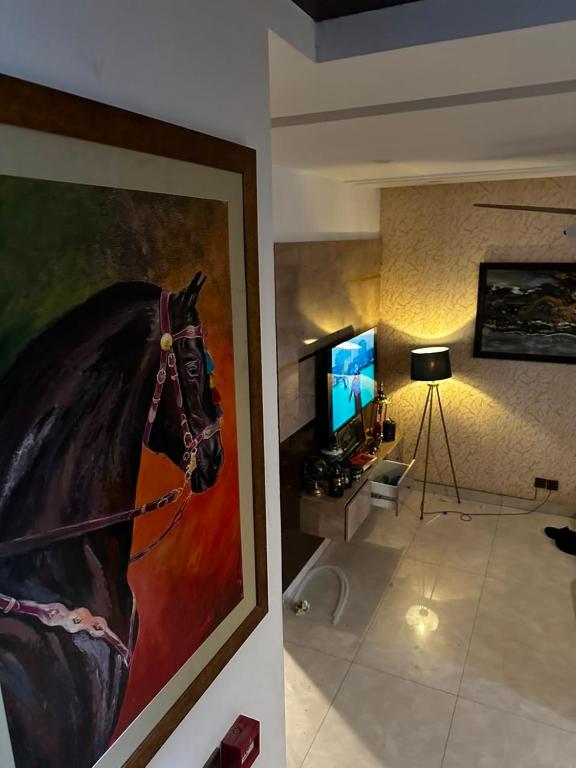 a living room with a painting of a horse on the wall at Prestige Home in Lahore