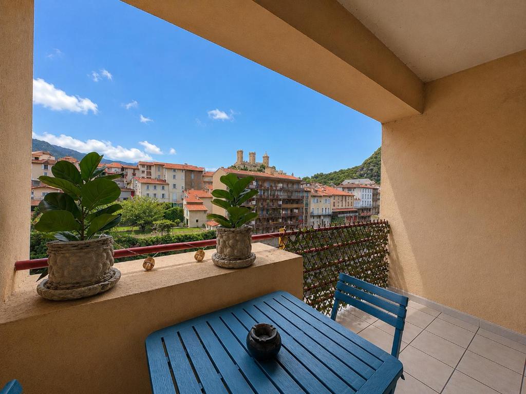 a blue bench and potted plants on a balcony at L'Observatoire Vue Château in Foix