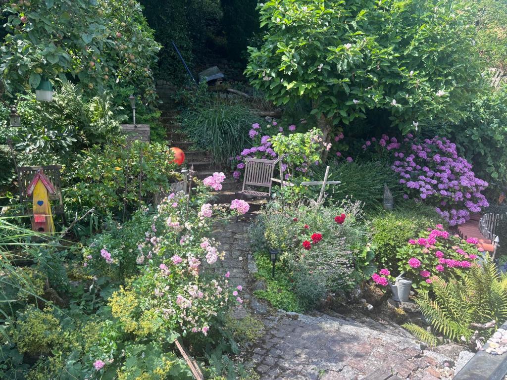 a garden filled with lots of flowers and a bench at Bed & Breakfast Bodensee mit Herz in Stockach