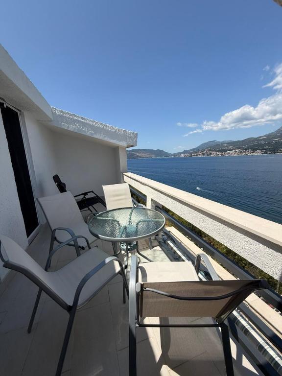a balcony with chairs and a table and the water at Ivanović smeštaj in Rose