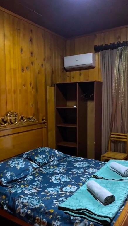 a bedroom with a bed with a blue comforter at double room in Ureki