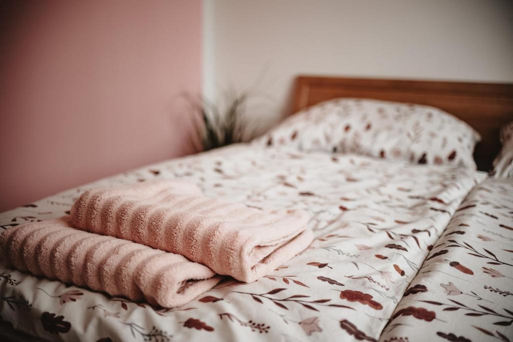 a bed with two pink towels sitting on it at H apartmán Jankov in Jankov