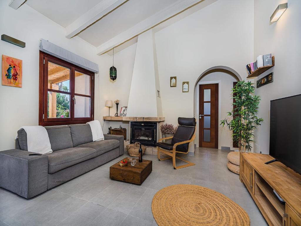 a living room with a couch and a fireplace at 3-Bed Villa with Pool, Puerto Pollença in Port de Pollensa