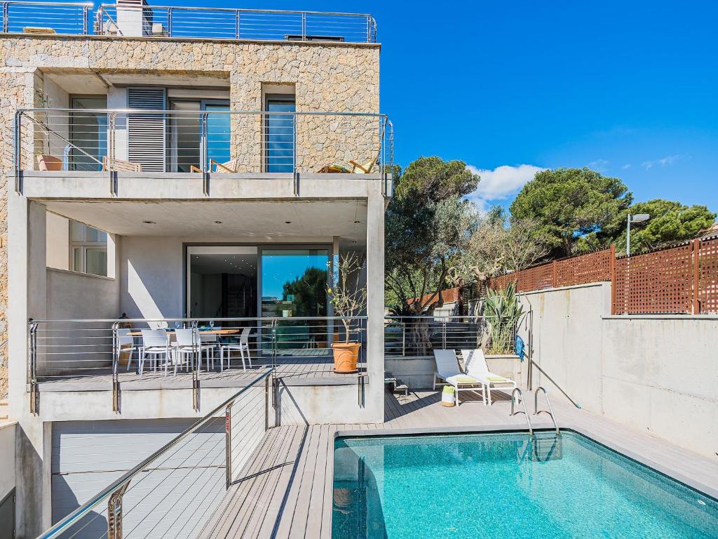 a house with a swimming pool and a balcony at Playa de Muro Chalet with Pool for 6 in Playa de Muro