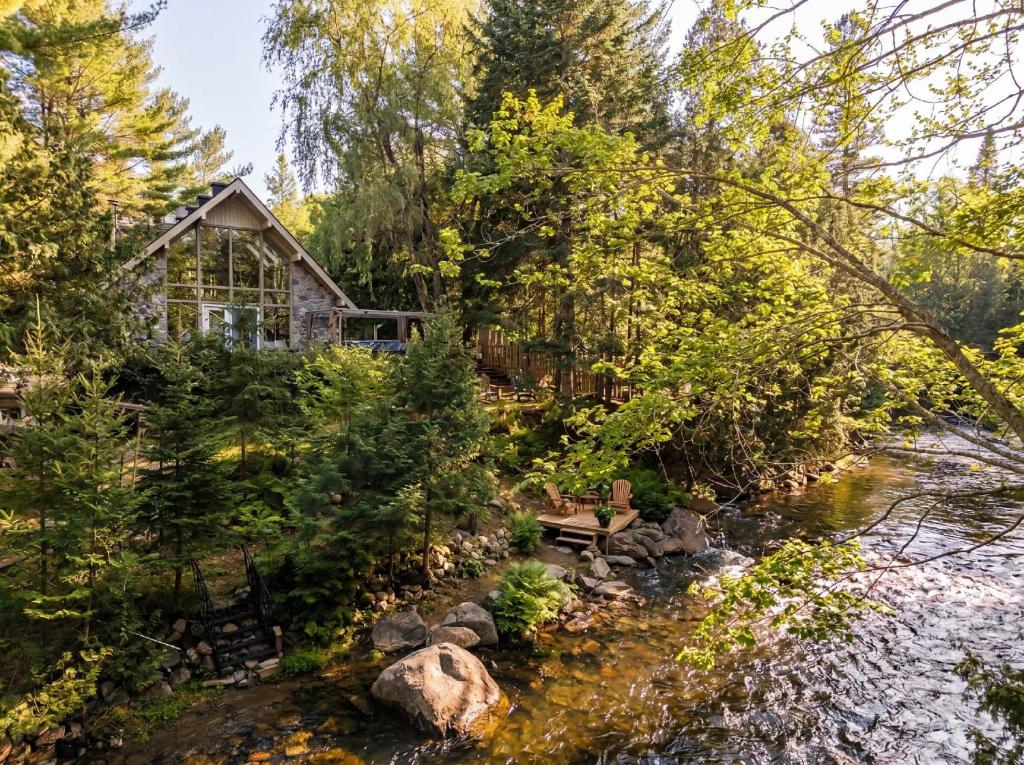 a house in the woods next to a river at Spa & River - Chalet de la riviere Pauze in Chertsey