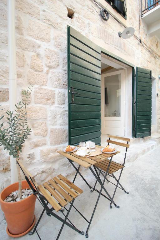 a table and chairs sitting next to a building at Almara stone house - Authentic stone house in Vis in Vis