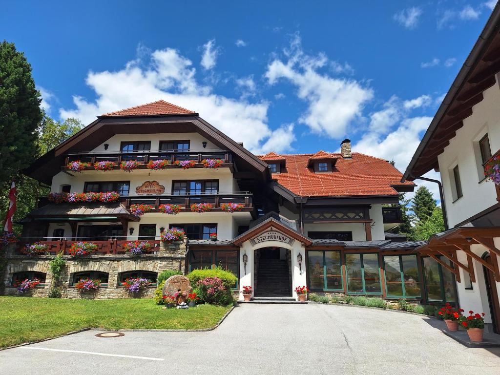 a large white house with a red roof at Hotel Stegmühlhof in Mauterndorf