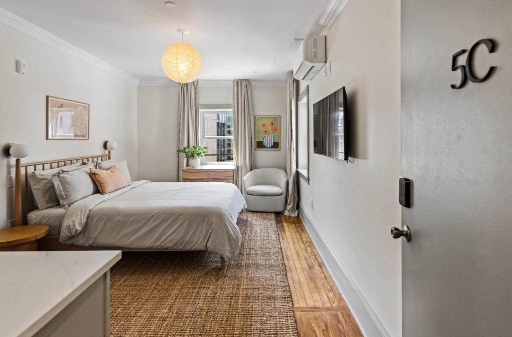 a small bedroom with a bed and a chair at Suite 5C at Maison Dupont a Dupont Circle Inn in Washington, D.C.