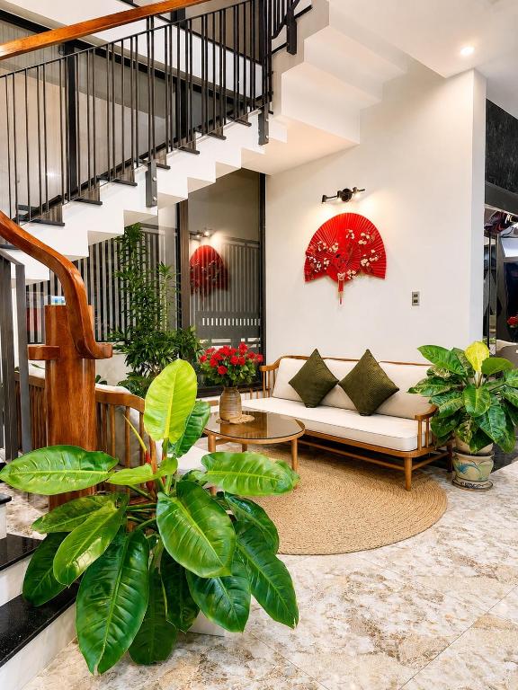 a living room with a couch and some plants at Saffron Boutique Hotel in Da Lat