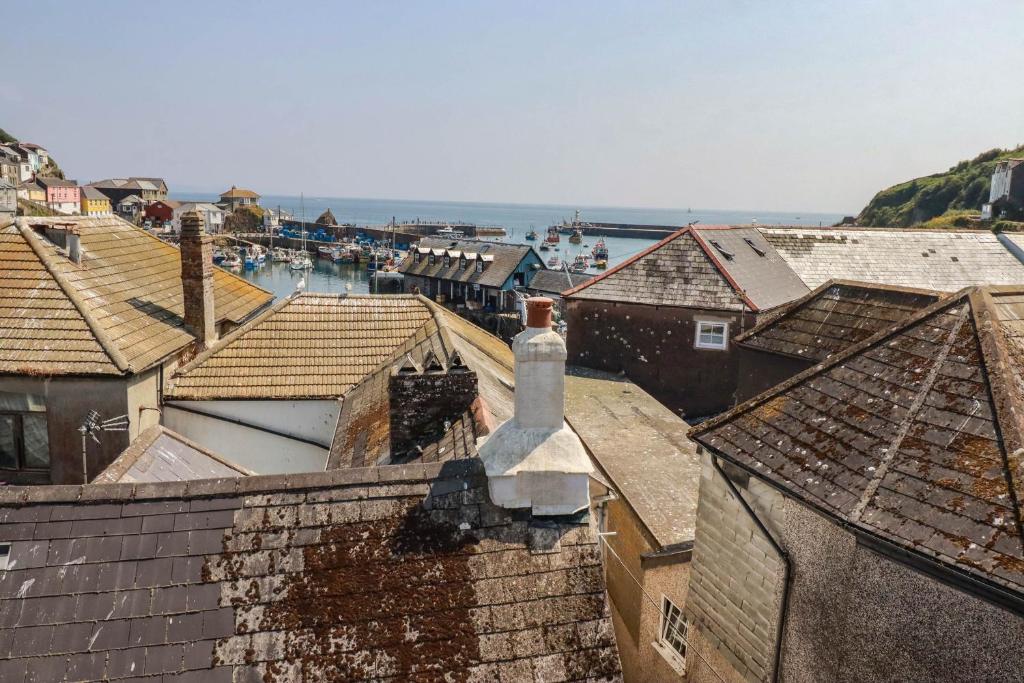 an aerial view of roofs of houses and the ocean at Stones Throw in St Austell