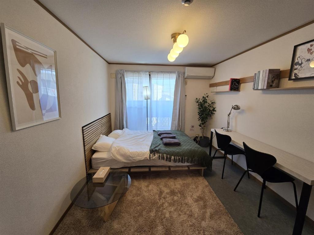 a bedroom with a bed and a desk and a window at Karawaru Stay 浦安 B303 Disney 9min in Tokyo