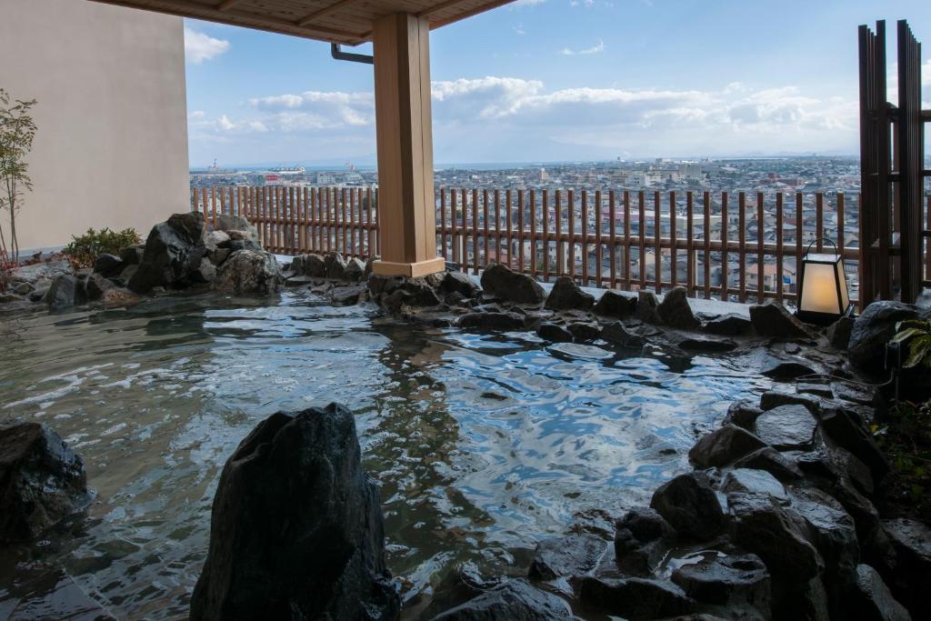 a pool of water with rocks in front of a building at Onyado Nono Sakaiminato Natural Hot Spring in Sakaiminato