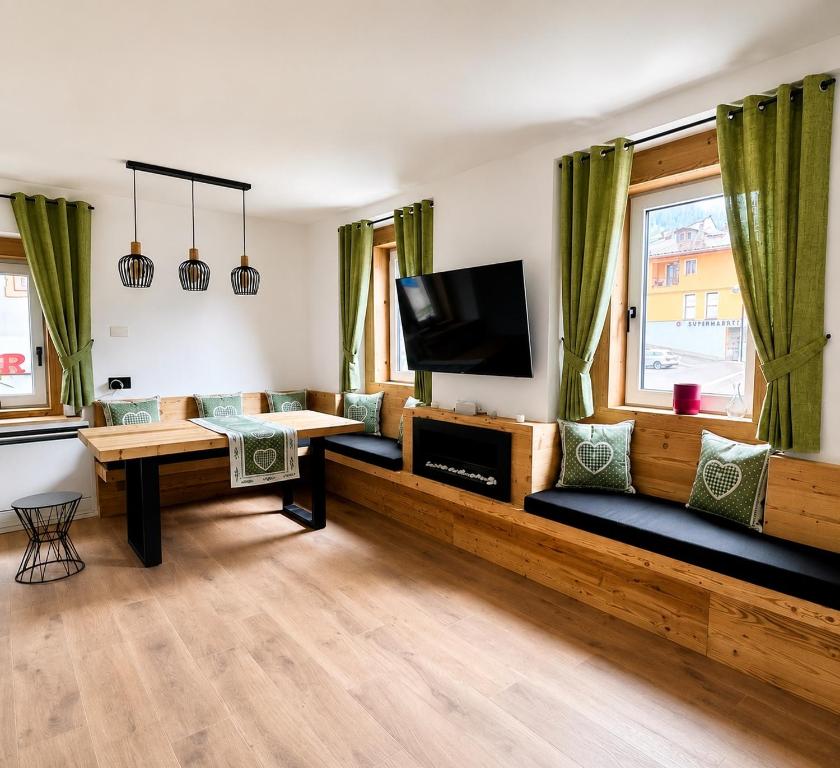 a living room with a table and a tv at Coriva Homes - Cogolo in Cogolo