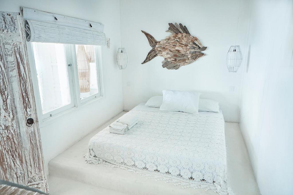 a bedroom with a bed with a fish on the wall at Sal Secret Spot in Uluwatu