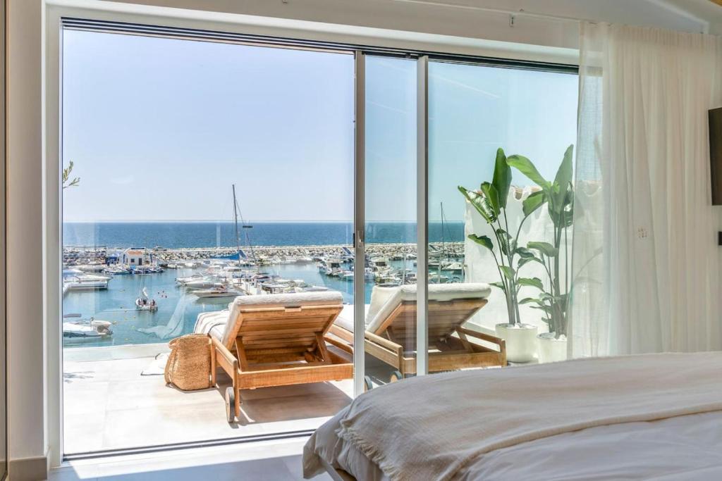 a bedroom with a large window with a view of a marina at Puerto Banus Duplex Lux Selection in Marbella