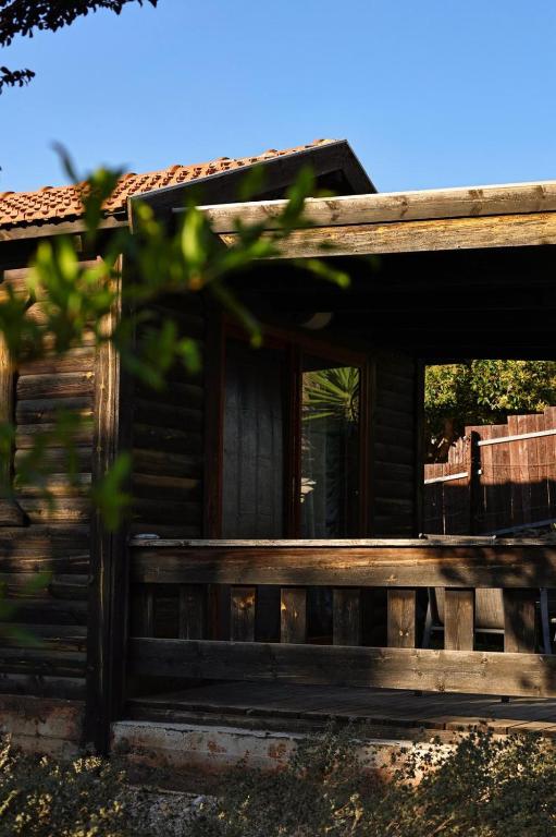 a wooden cabin with a porch and a window at Orr Halevana in Bruchim Qela' Alon