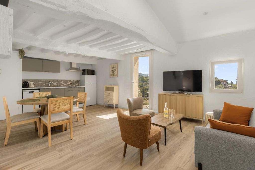 a living room with a table and chairs and a kitchen at apt hospital in Tourrettes-sur-Loup