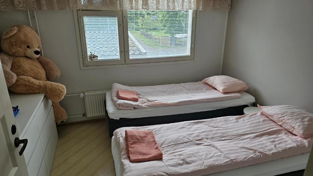 a small room with two beds and a teddy bear at Savonlinnan keskusta in Savonlinna