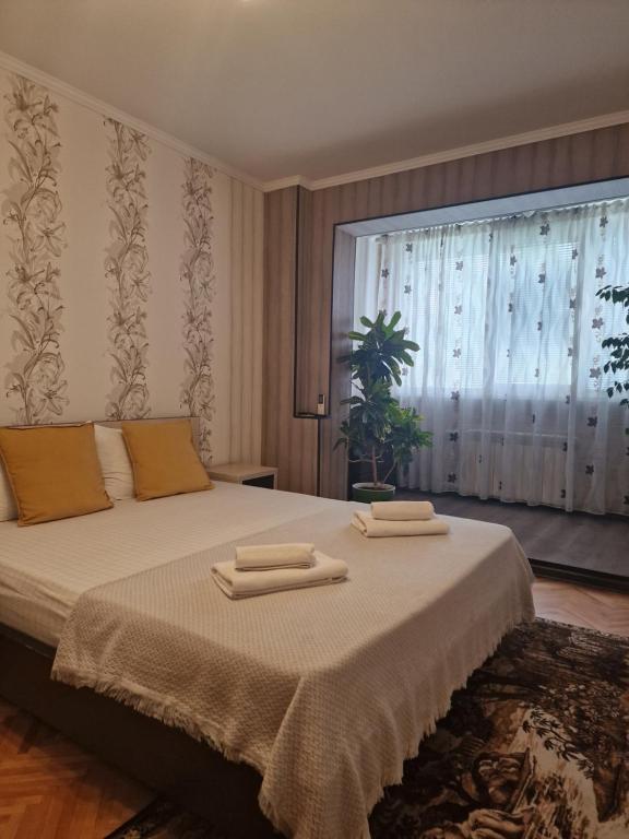 a bedroom with a large bed with two towels on it at Three Rooms Comfort in Chişinău