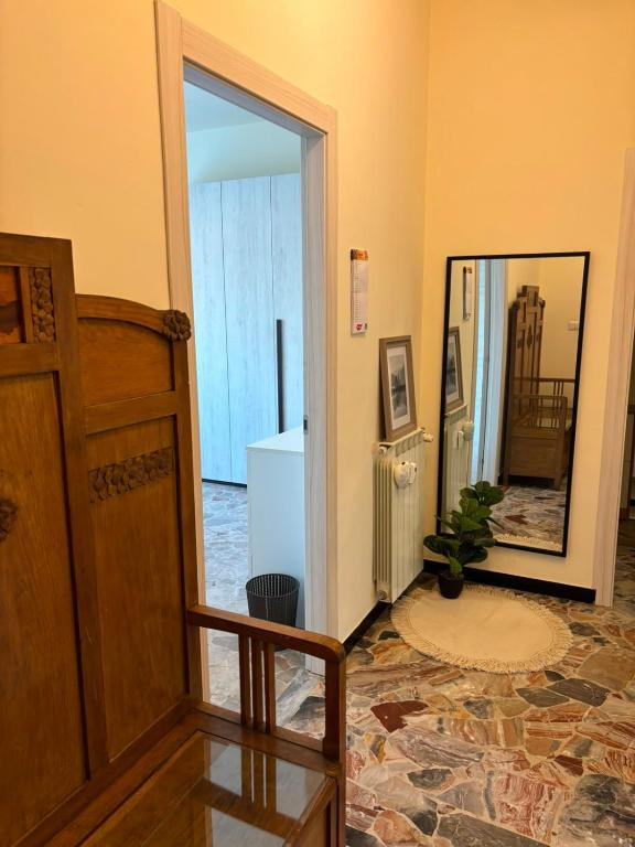 a hallway with a door and a staircase with a mirror at Nicole's House in Asti