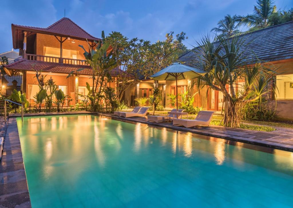 a swimming pool in front of a house at Ubad Retreat in Ubud