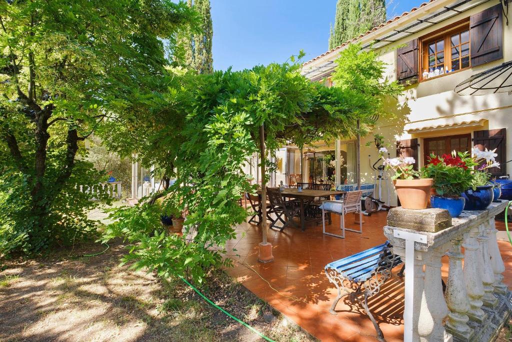 a house with a bench and a table with plants at La Lufrerie in Sospel