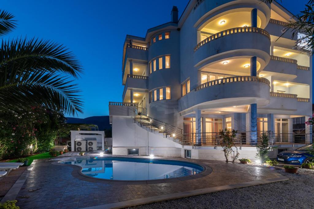 a large building with a swimming pool in front of it at Villa Ani in Trogir