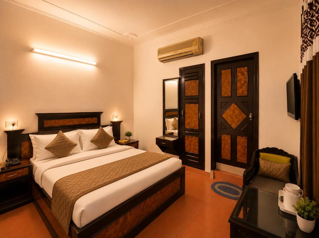 a bedroom with a bed and a desk and a television at Hotel Arina in Chandīgarh
