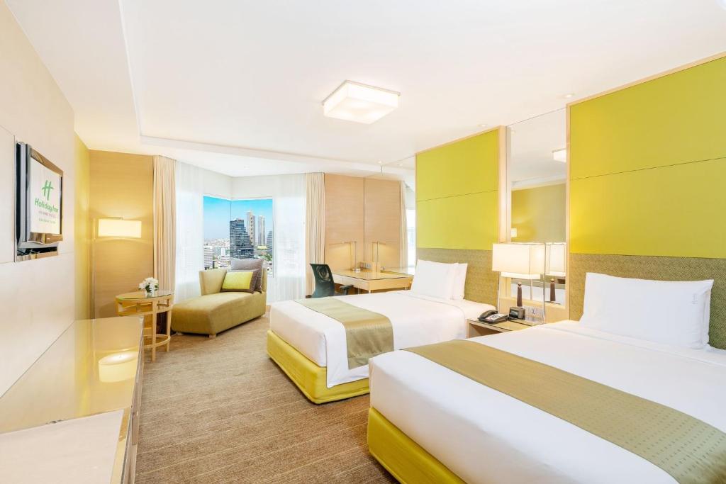 A bright twin room with lime-green accents, a window-side sofa and a compact desk.