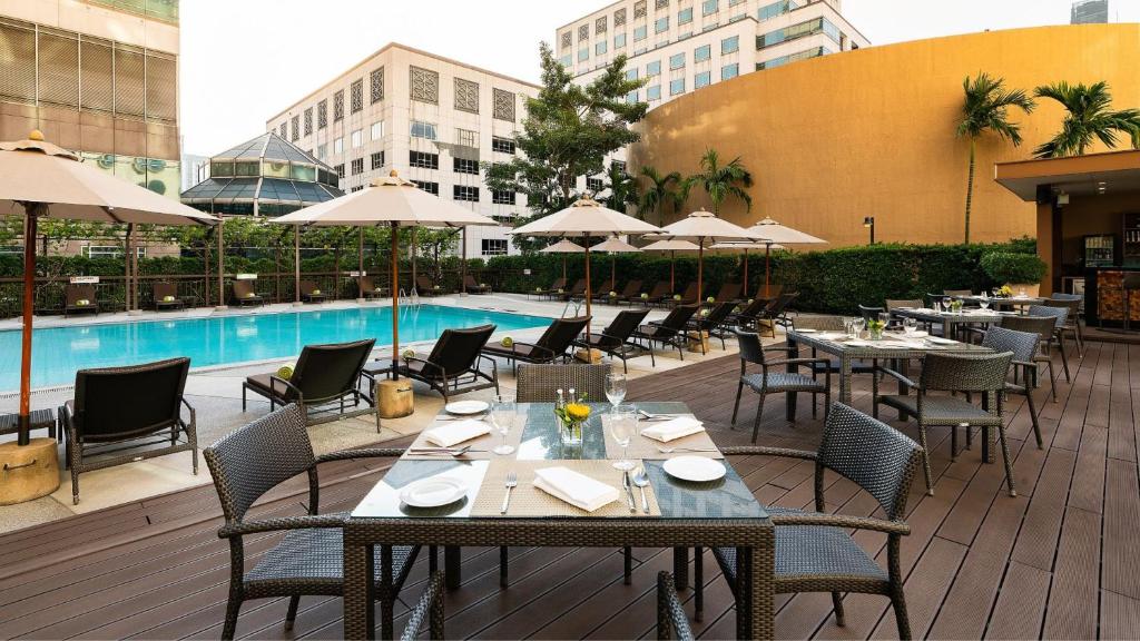 A rooftop-style pool deck combines loungers, shaded tables and outdoor dining.