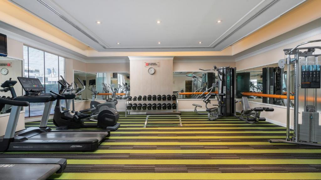A bright fitness room provides treadmills, cardio machines, free weights and a cable station.