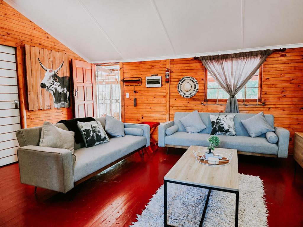 a living room with two couches and a table at Mike's Lodge Sodwana Bay in Sodwana Bay