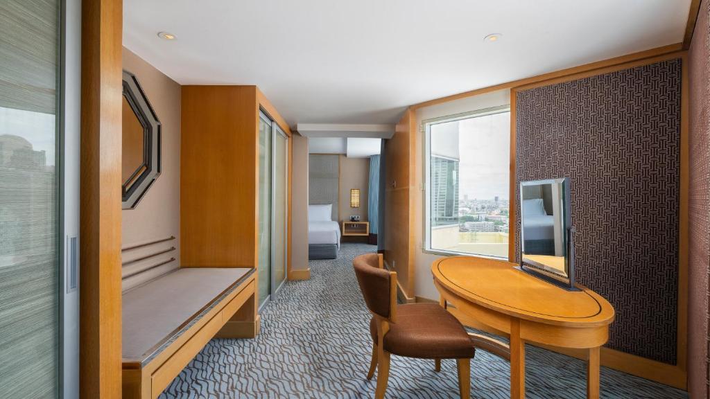 A compact in-room work and dressing area beside a large window.