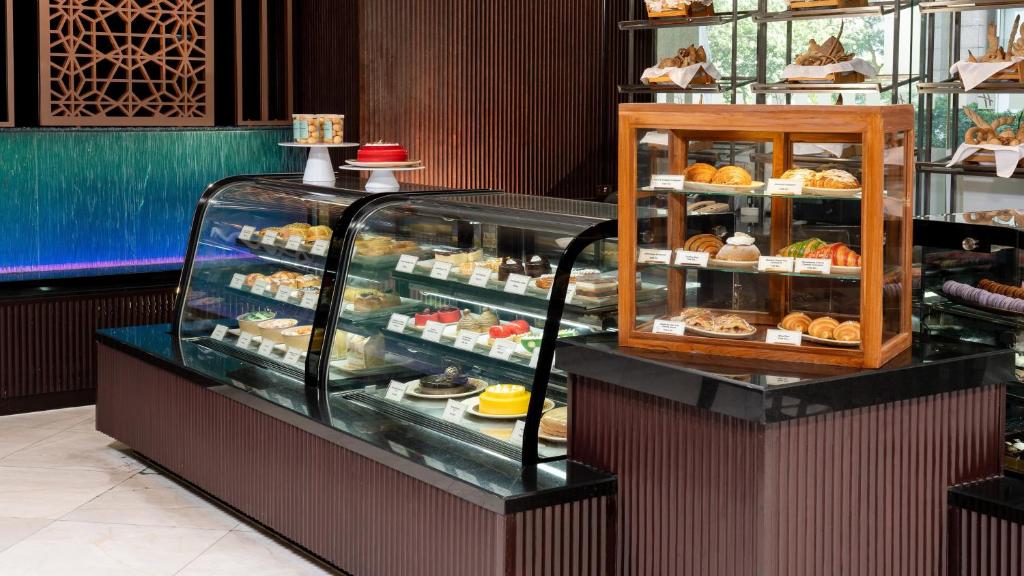 A bakery counter displays pastries, breads and chilled desserts.