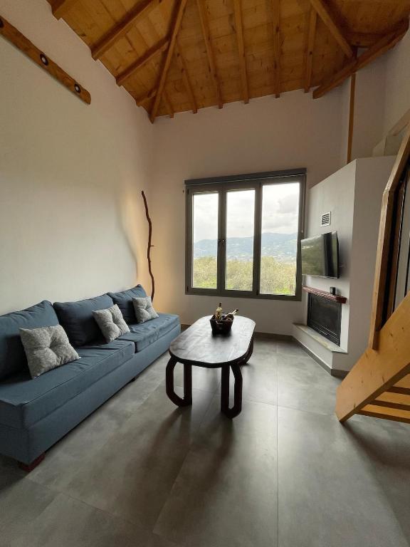 a living room with a blue couch and a table at Faos residence I in Pefkias