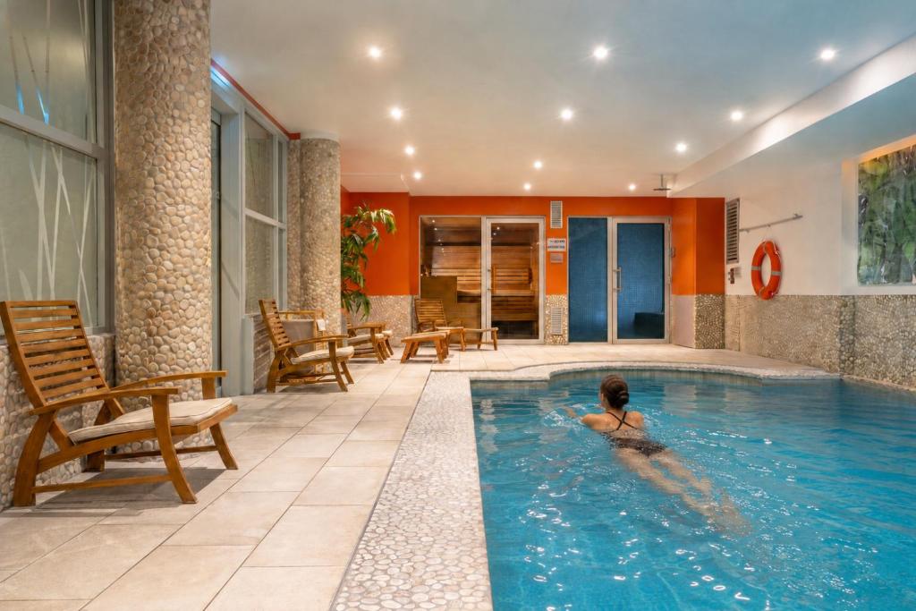 a person in a swimming pool in a hotel at Urban Hotel & Spa Aix-les-Bains - BW Signature Collection in Aix-les-Bains