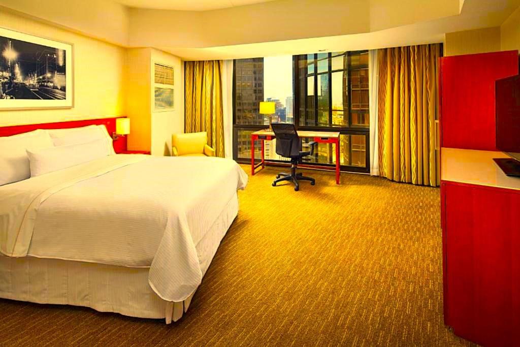 a hotel room with a large bed and a desk at Hotel Manurita Palace in Dhanbād