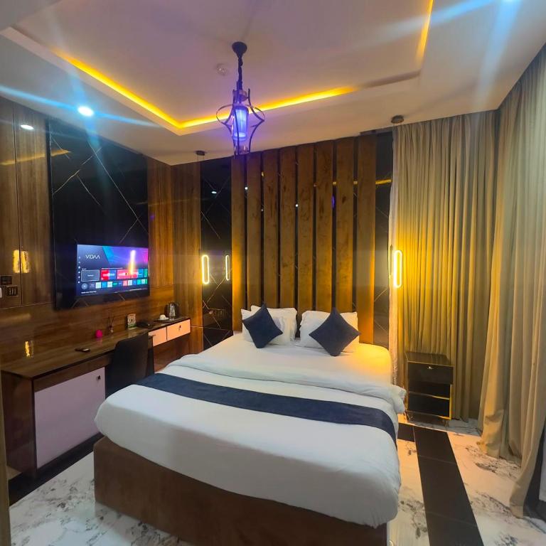 a bedroom with a large bed and a television at Classy Castle Hotel And Suite in Ughelli