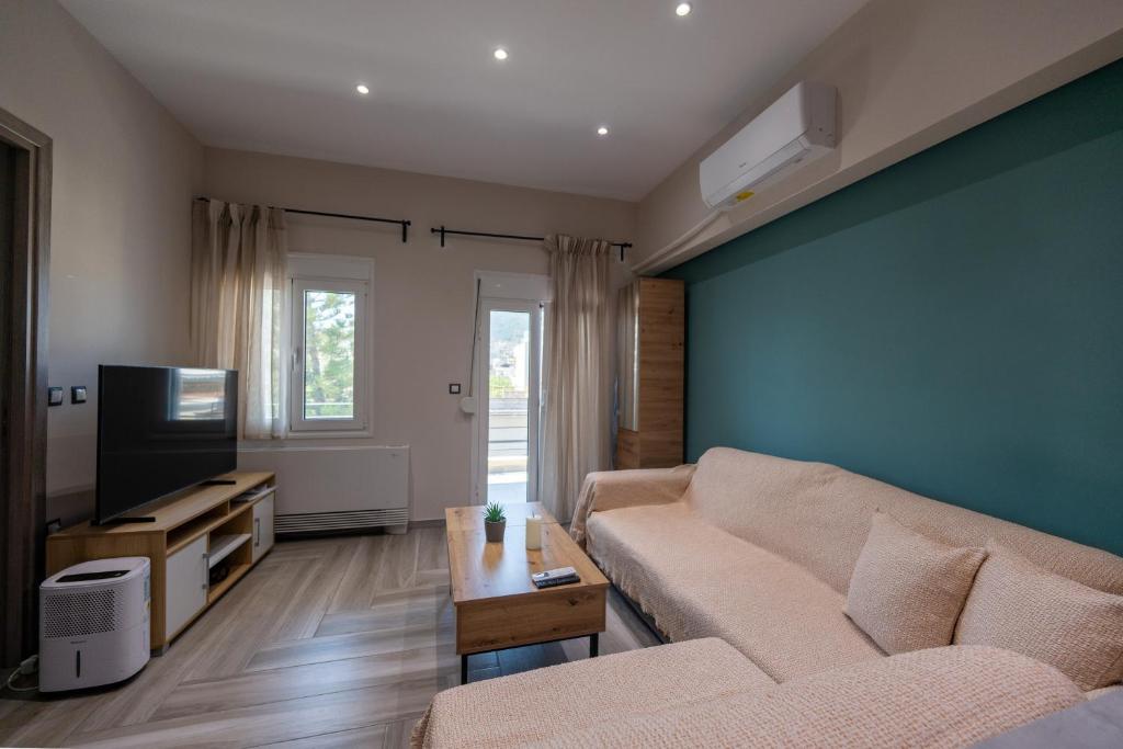 ein Wohnzimmer mit Sofa und Fernseher in der Unterkunft Xenophon Studios in Mytilini