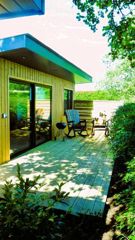a house with a deck with a bench on it at An Garraí Mór in Omagh