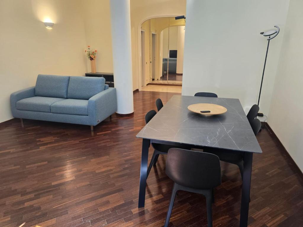a dining room with a table and a blue couch at La Felce in Cernobbio