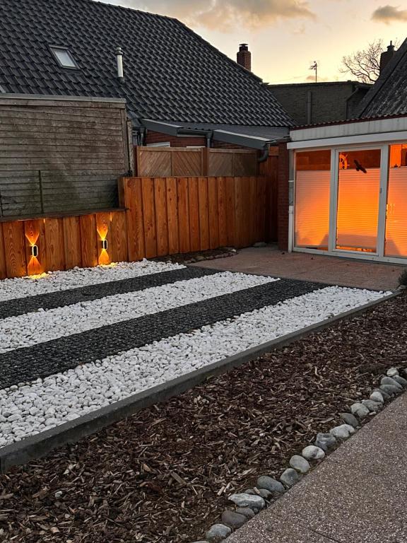 a backyard with a stone walkway in front of a house at Ferienhaus Fehmarnliebe in Fehmarn