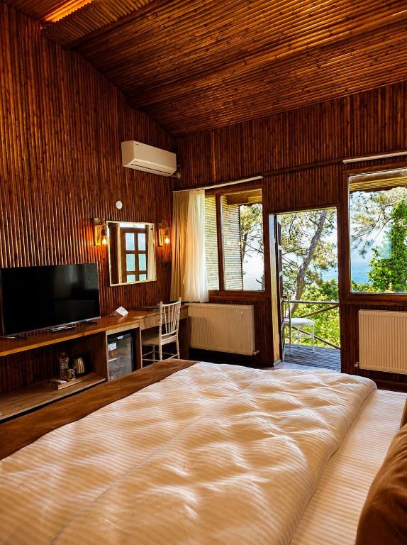 a bedroom with a large bed and a television at Diamond Koru Hotel in Amasra