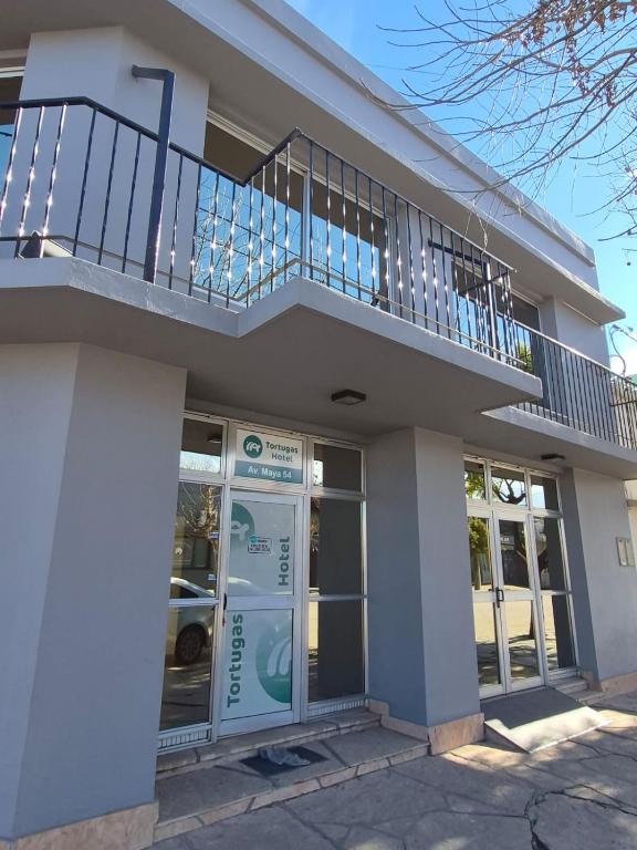 a building with a balcony on top of it at Tortugas Hotel in Carlos Casares