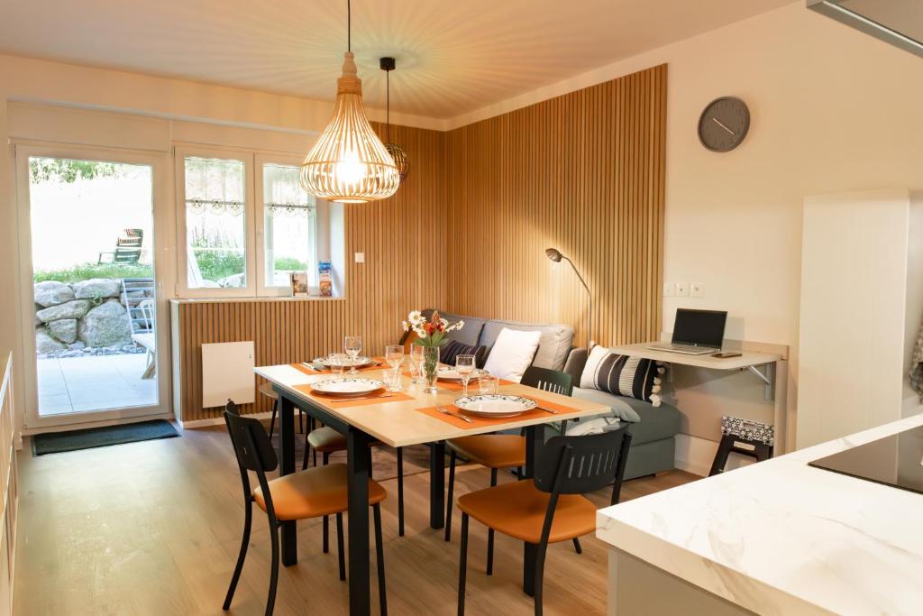 a dining room and living room with a table and chairs at Cocon d'Altitude avec Terrasse, Calme & Parking Privé in Orbey