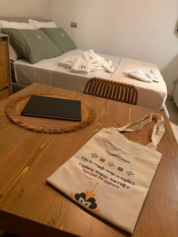 a table with a bag on it with two beds at Wonderhouse in Polignano a Mare