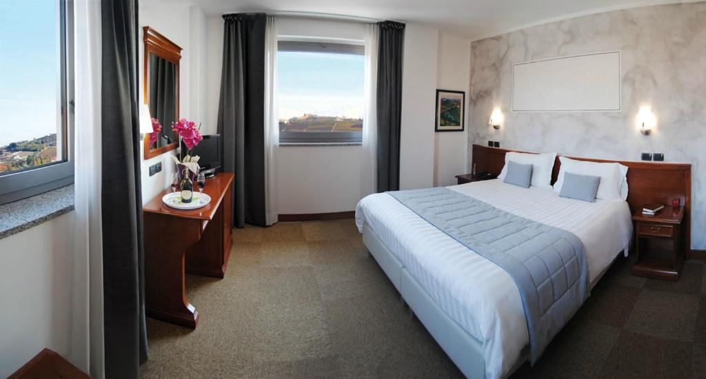 a hotel room with a large bed and a window at Hotel Medea - Adults Only in Alba